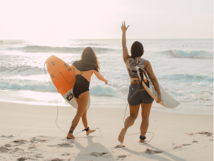 Two girls on a beach with surfboards - Duas meninas na praia com pranchas de surf