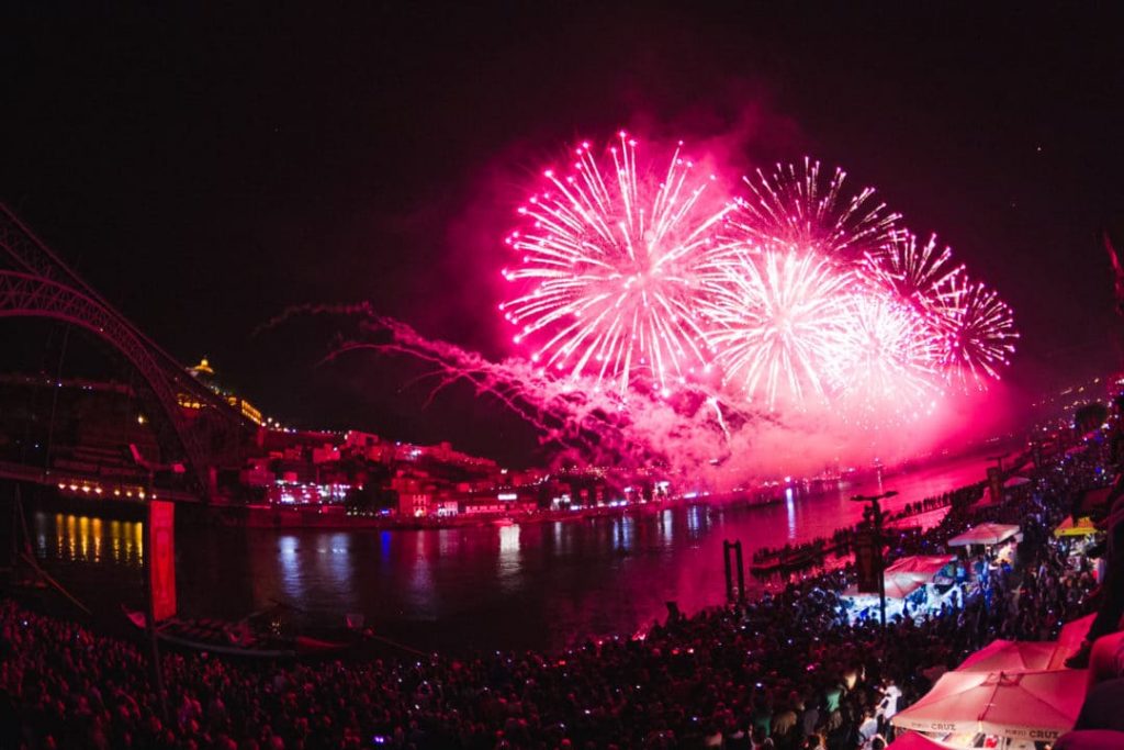 Plano aberto sobre Fogos de Artificio no Rio Douro, com tons rosa, nas festas de São João Porto